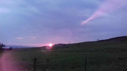 un campo con il tramonto in lontananza di Tigh A Raoin a Portree