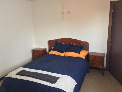 a bedroom with a bed with blue and orange pillows at Villafranca hostel in Cuenca