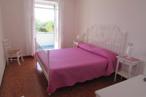 a bedroom with a large bed with a pink blanket at Casa Antonio in Ischia