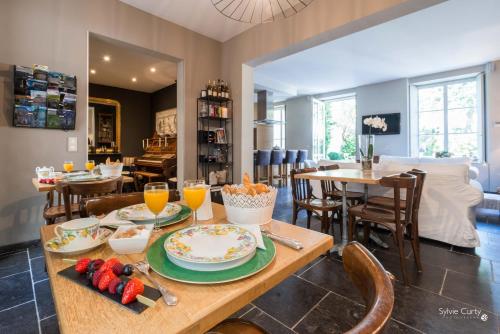 a dining room with a table with food on it at Entre Hotes in La Rochelle