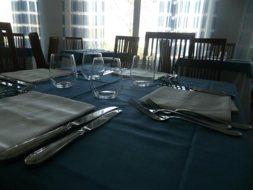 a table with a blue table cloth and silverware at Hotel Panoramic in Giardini Naxos