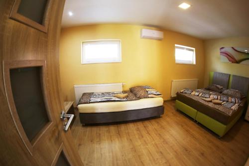 a room with two beds in a room with a door at Apartmány Dimitra in Štúrovo