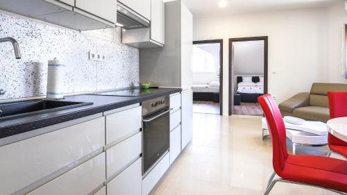 シオーフォクにあるWhite Apartman Siófokのキッチン(シンク、テーブル付)