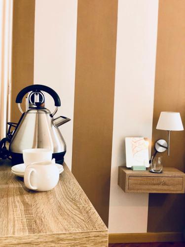 a tea kettle sitting on a wooden table with a cup at Palazzina300 in Treviso