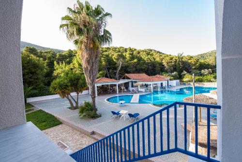 uma vista para uma piscina a partir de uma varanda de um resort em Vassilis Studios em Poros