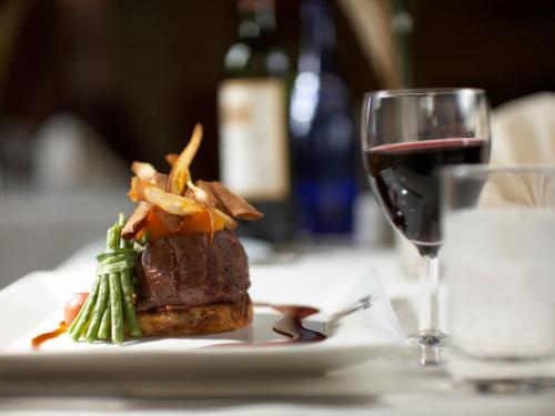a plate with a steak and a glass of wine at Metropole Hotel and Spa in Llandrindod Wells