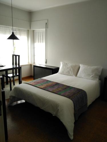 a bedroom with a large bed and a desk and window at Quinta Nova do Almeida in Alcobaça