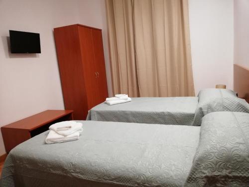 a hotel room with two beds and a tv at B&B Altamarea in Marina di Schiavonea
