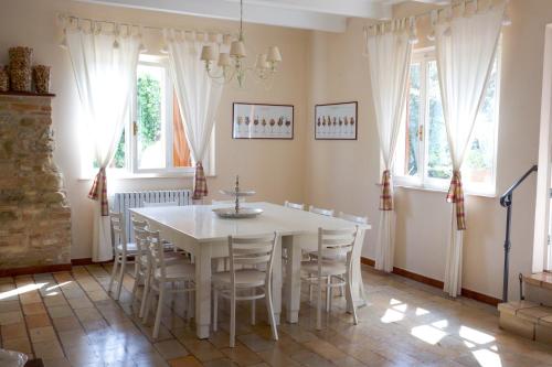 ein Esszimmer mit einem weißen Tisch und Stühlen in der Unterkunft Casa vacanze a Rubbianello in Monterubbiano