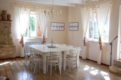 a dining room with a white table and chairs at Casa vacanze a Rubbianello in Monterubbiano