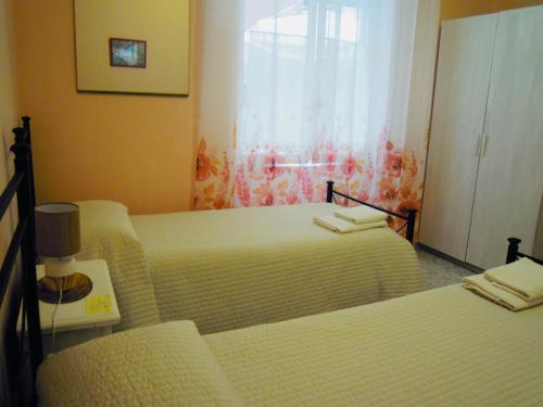 a hotel room with two beds and a window at Affittacamere Benvenuti Monterosso in Monterosso al Mare