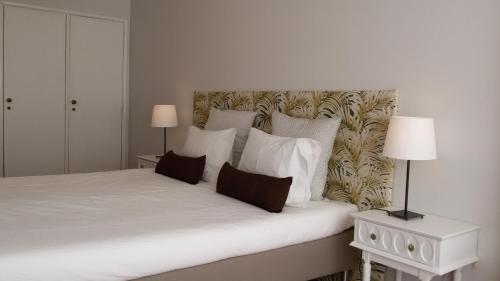 カルカヴェロスにあるCarcavelos Beachのベッドルーム1室(白いシーツと枕のベッド1台付)