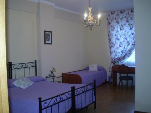 1 dormitorio con 2 camas y lámpara de araña en Vacanze Senesi, en Siena