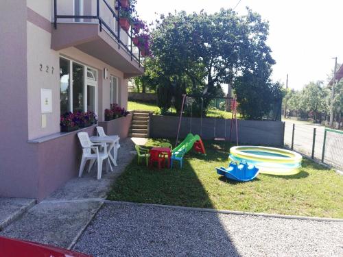 a backyard with a play yard with chairs and a playground at Apartment Beha in Bihać