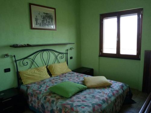 Costaraineraにあるla casa di leleの緑の壁のベッドルーム1室(窓付)