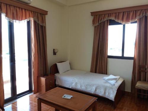 ジロカストラにあるQiqi Hotelのベッドルーム1室(ベッド1台、テーブル、窓付)