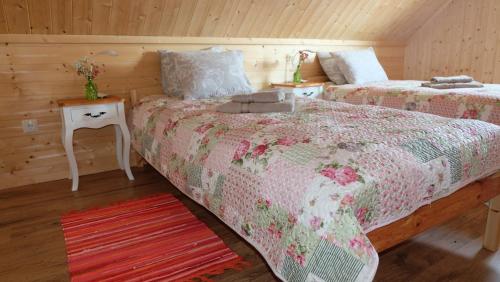 ein Schlafzimmer mit 2 Betten und einem Nachttisch mit einem Tisch in der Unterkunft Tahula Puhkemaja in Tahula