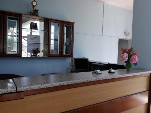 a kitchen with a counter with flowers on it at Qiqi Hotel in Gjirokastër