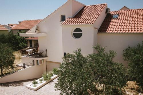 a white house with a red roof at Fyaka Loft Apartments in Vodice