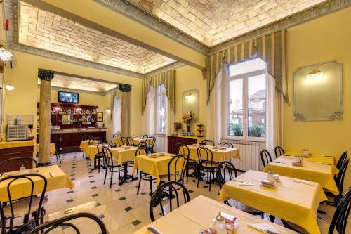 a dining room with yellow tables and chairs at Cambridge Hotel in Rome