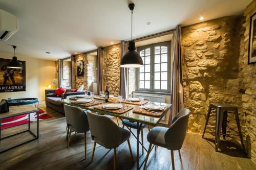 une cuisine et un salon avec une table et des chaises dans l'établissement Le Grand Duplex de Rafael, à Sarlat-la-Canéda