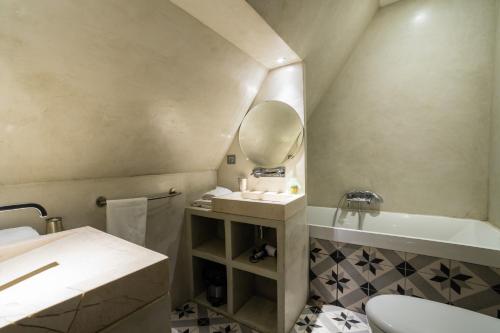 a bathroom with a sink and a mirror and a tub at Le Grand Duplex de Rafael in Sarlat-la-Canéda