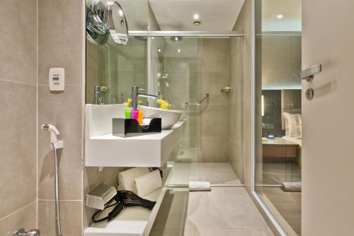 
a bathroom with a toilet, sink, and shower at Meliá Paulista in São Paulo
