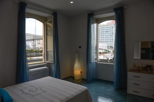 ナポリにあるCasa del Porto al Borgo Marinariのベッドルーム1室(窓2つ、ベッド1台、ドレッサー付)