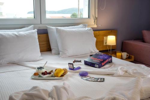 a tray of food on top of a bed at Isalos Suites in Néa Péramos