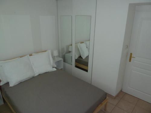 une petite chambre avec un lit et un miroir dans l'établissement Palais des domes, à Nice