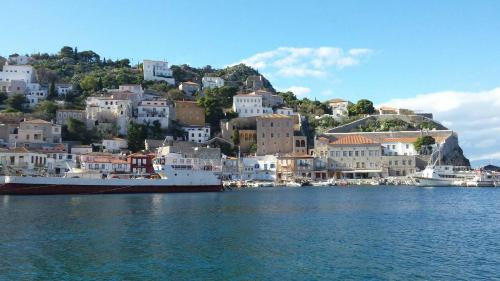 a boat is docked in the water near a town at Hydra Memories House in Hydra