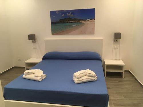 a bedroom with a blue bed with towels on it at B&B Marconi in Favignana