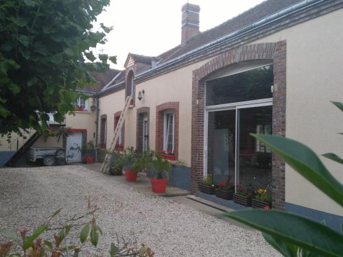 a courtyard of a house with potted plants at La cité des abeilles in Villemandeur