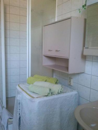 a bathroom with a sink and a cabinet and towels at Zur alten Eiche in Stepenitz