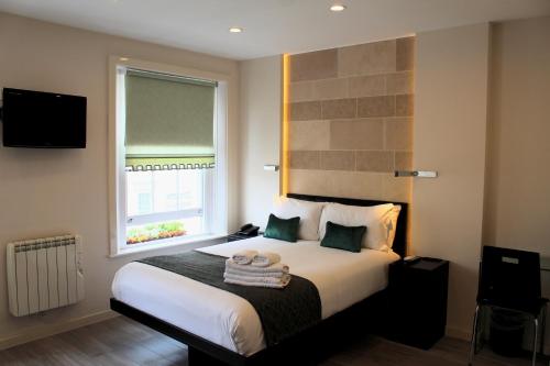 a bedroom with a large bed with a window at 25 Paddington Hotel in London