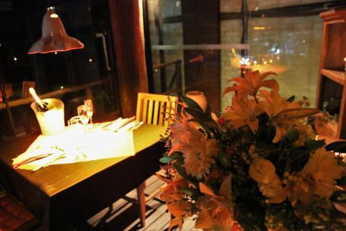 a table in a restaurant with a vase of flowers at Ilha de Toque Toque Eco Hotel in São Sebastião