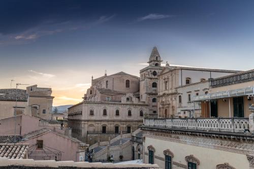 an old building with a clock tower in a city at Hotel Porta Reale in Noto