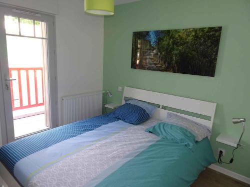 a bed in a bedroom with a large window at Villa du Cabestan in Andernos-les-Bains