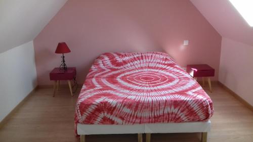 una camera con letto e piumone rosso di Gite de la forêt a Les Hogues