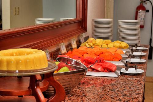 a buffet of fruit on a table in front of a mirror at Astur Hotel & Residence in Veracruz