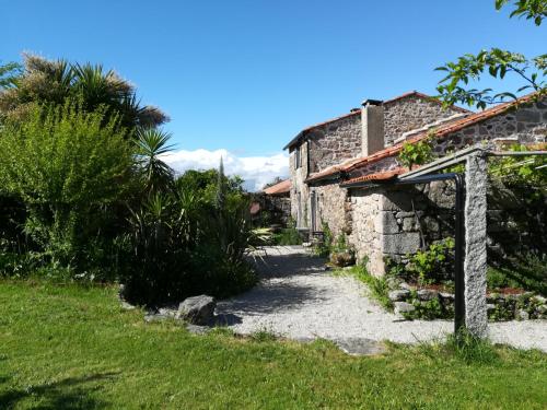 an old stone house with a pathway at O Curralino in Vilacoba