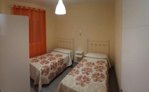 Casa los Naranjos 1 في كونيل دي لا فرونتيرا: سريرين في غرفة صغيرة بها