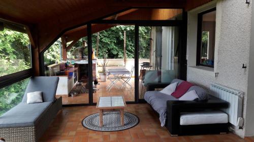 a living room with a couch and a table at B&B En plein coeur de la forêt in Artiguelouve