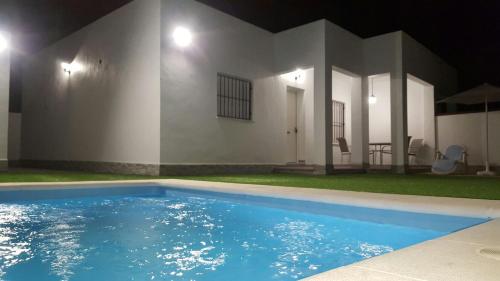 a swimming pool in front of a house at night at Casa los Naranjos 1 in Conil de la Frontera