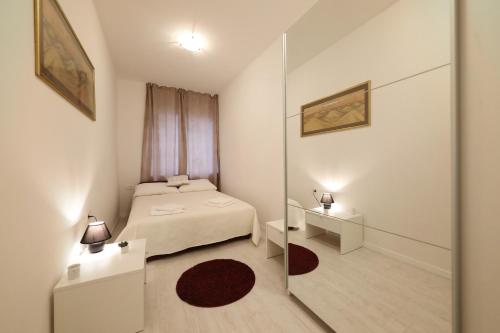 een kleine slaapkamer met een bed en een spiegel bij Apartment Luci in Zadar