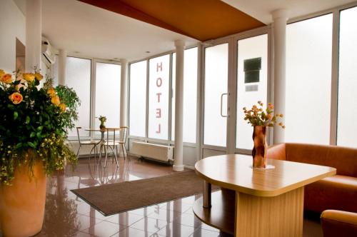 um átrio com uma mesa e flores num quarto em Hotel Est em Bucareste