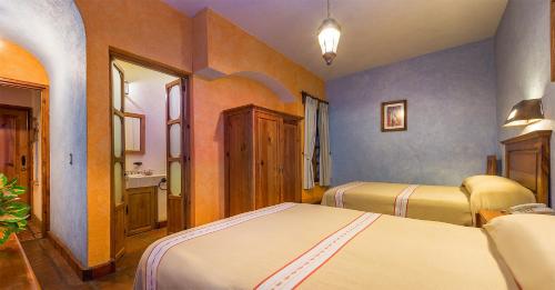 a bedroom with two beds and a sink in it at Hotel Refugio del Angel in Pátzcuaro