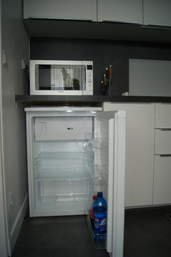 un réfrigérateur vide avec un four micro-ondes dans la cuisine dans l'établissement Jordan, proche centre, wifi, linge, produits, ménage,, à Reims