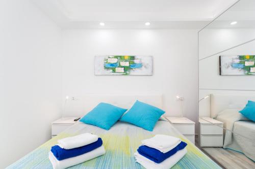 Un dormitorio con una cama con almohadas azules y blancas. en 241 Quiet Bungalow with terrace, en Playa de las Américas