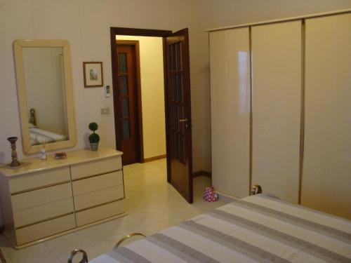 a bedroom with a bed and a large mirror at Casa delle Pomelie - Taormina & Etna Panoramic Views in Riposto